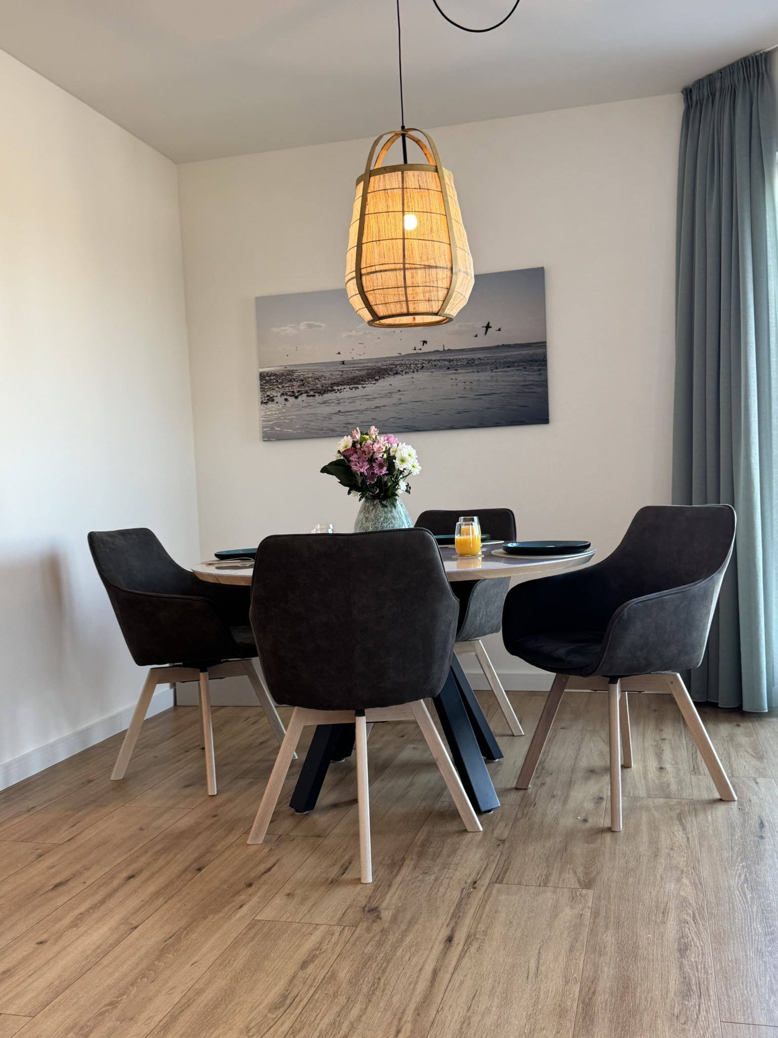 Gedeckter Esstisch unter Rattan-Leuchte